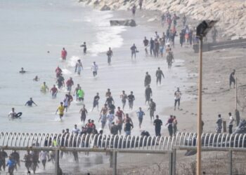 Cientos de personas cruzan a nado a Ceuta desde Marruecos con una multitud esperando al otro lado de la frontera