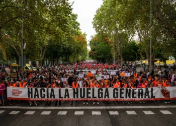 Numerosas personas sostienen una pancarta con lema 'Hacia la huelga general' durante la manifestación para exigir una re