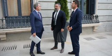 Archivo - El presidente del PP, Alberto Núñez Feijóo (i) conversa con el presidente de VOX, Santiago Abascal (c), a su s